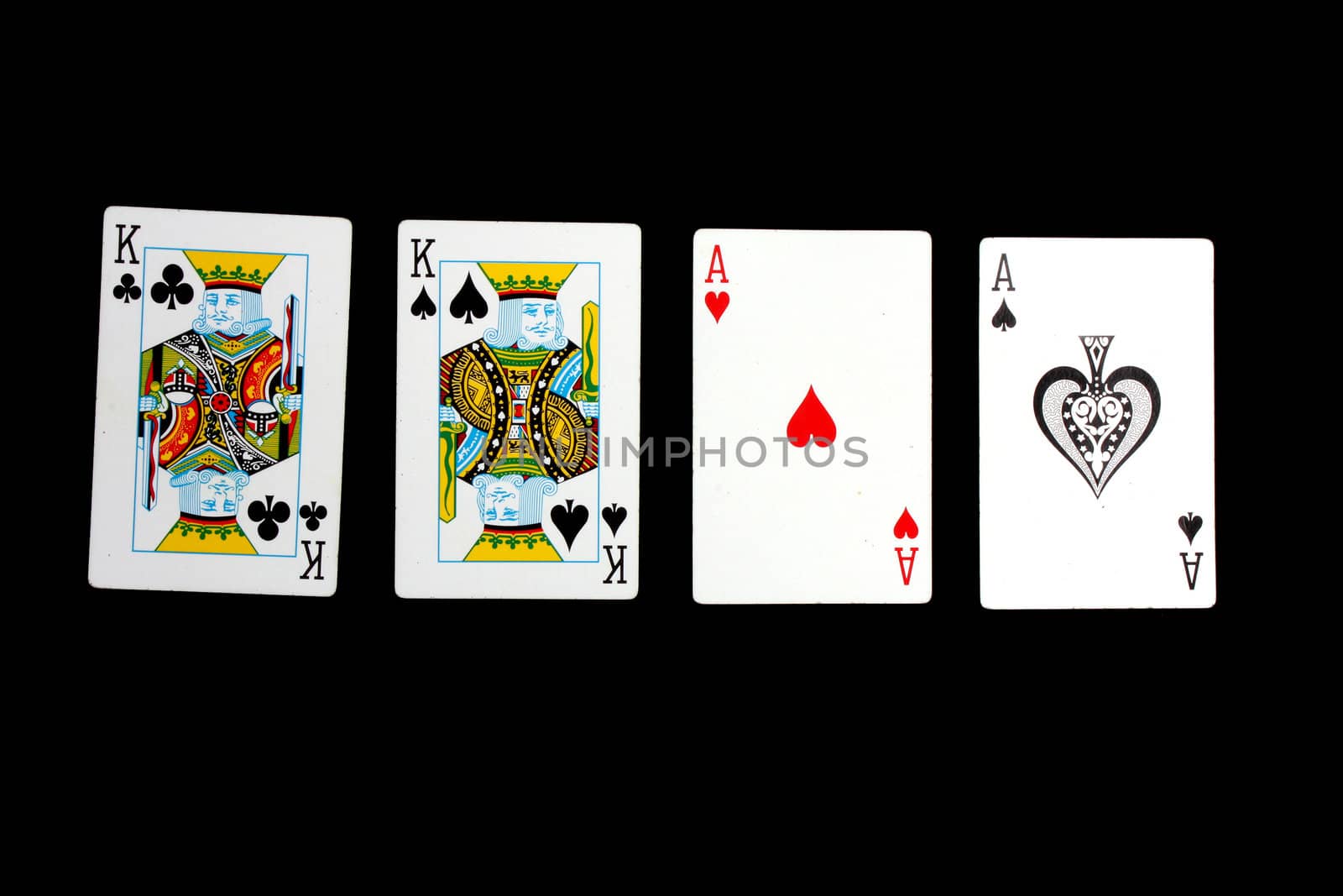 A poker hand of two pairs, consisting of a pair of kings and aces, on black background.