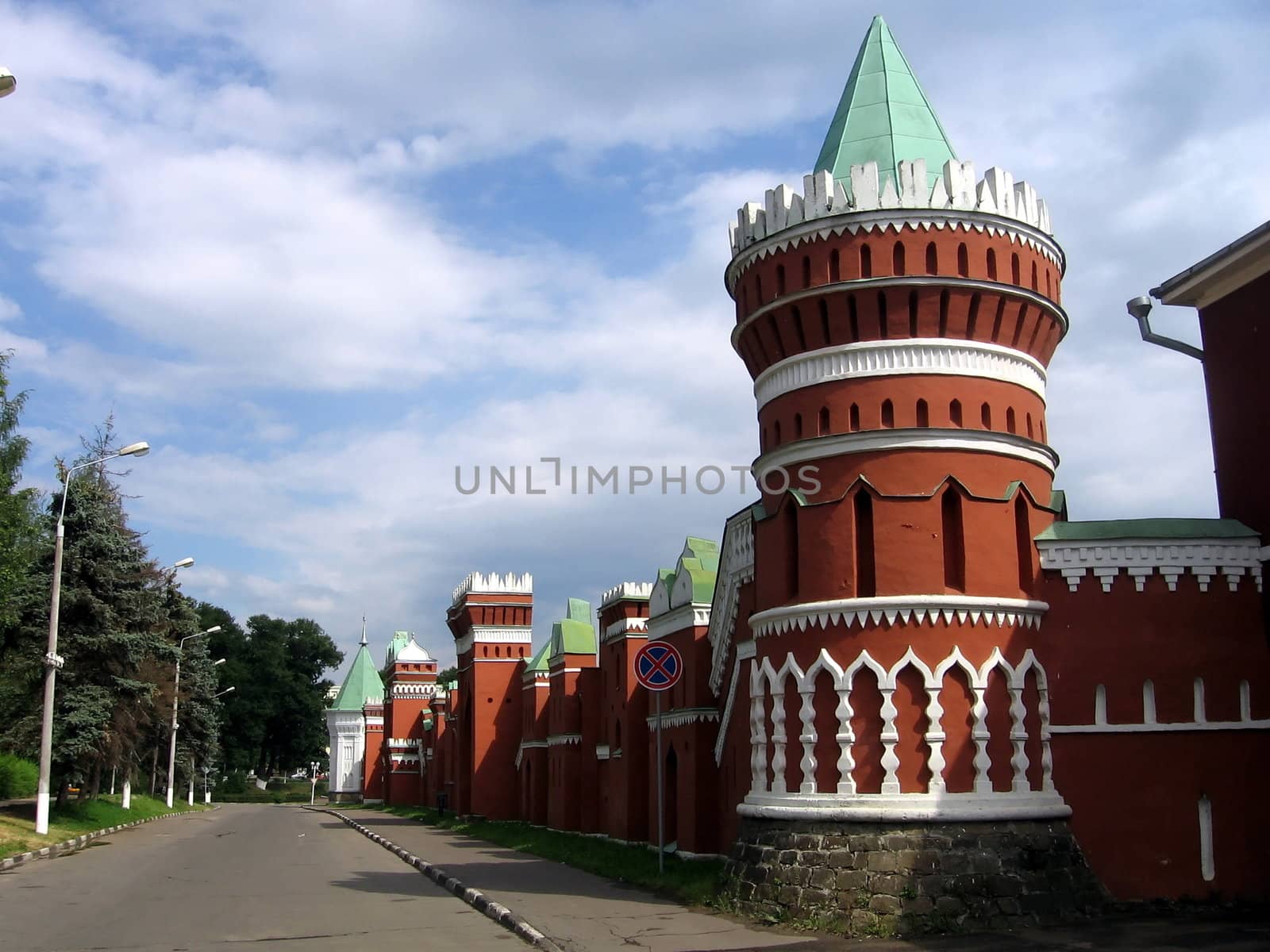 Red Kremlin wall on a background of blue sky with clouds