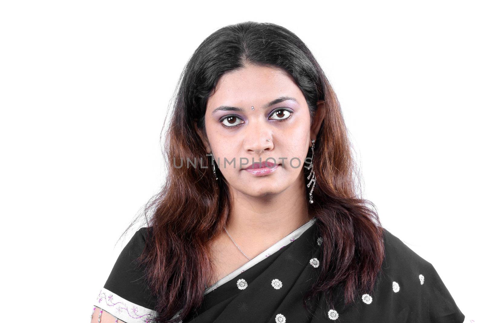 A portrait of an angry Indian woman wearing a traditional black sari, on white studio background.
