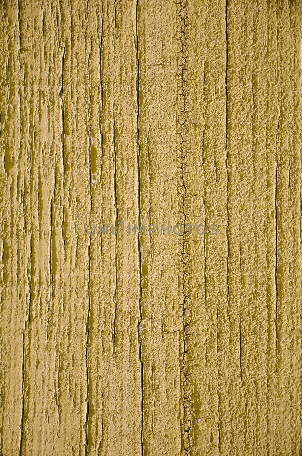 Yellow flaky paint on a wood background.