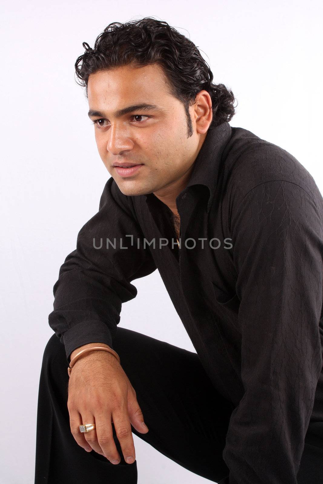 A portrait of a handsome Indian guy, on white studio background.