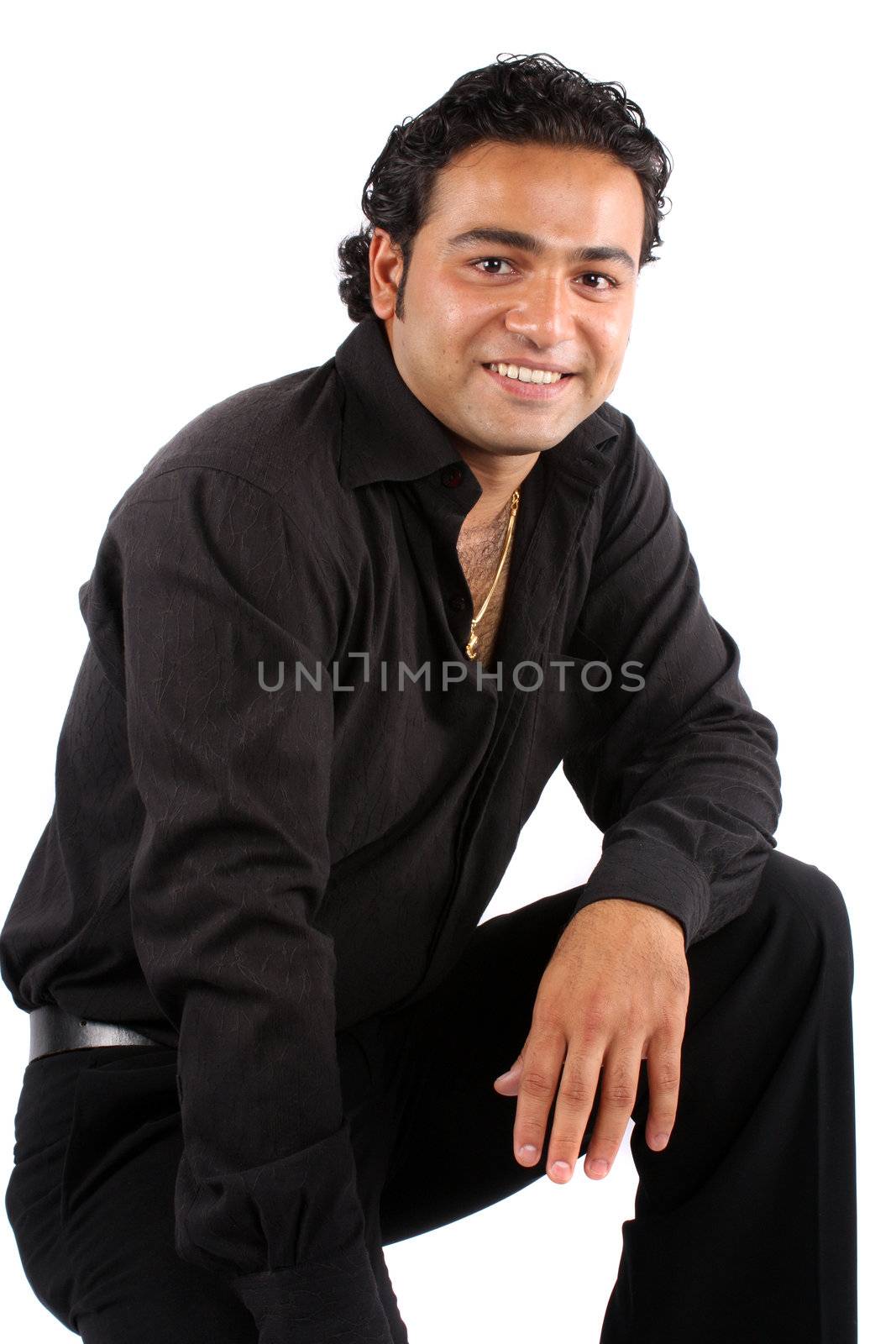 A portrait of a handsome Indian man in a black shirt and trousers, on white studio background.