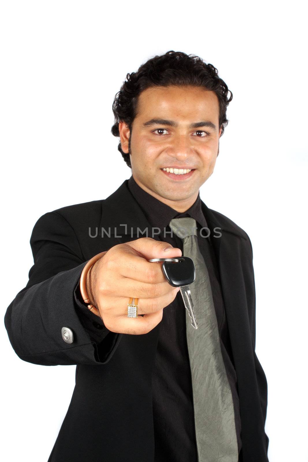 An Indian sales executive handing over the keys of a car to a customer, on white studio background. Focus on keys.
