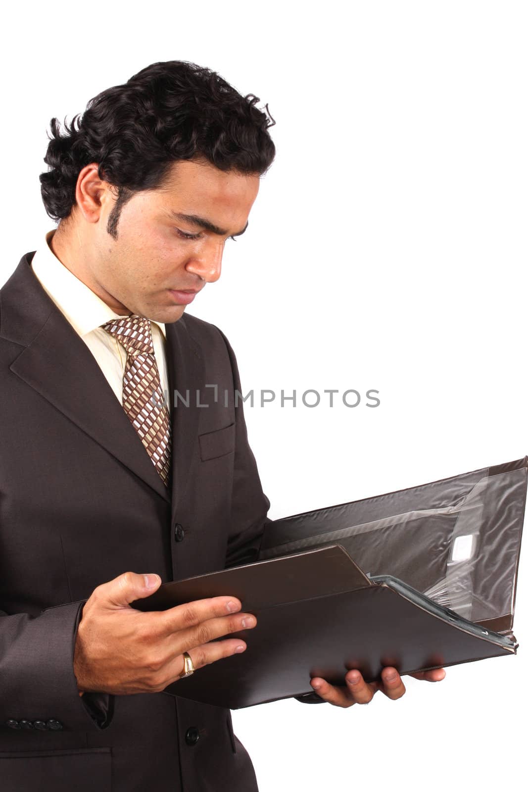 An Indian businessman checking documents in a file, on white studio background.