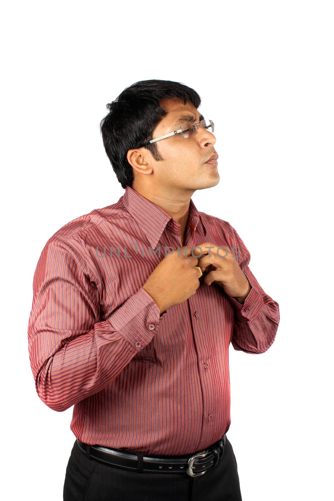 An Indian businessman getting prepared for his office wearing a striped shirt, on white studio background.