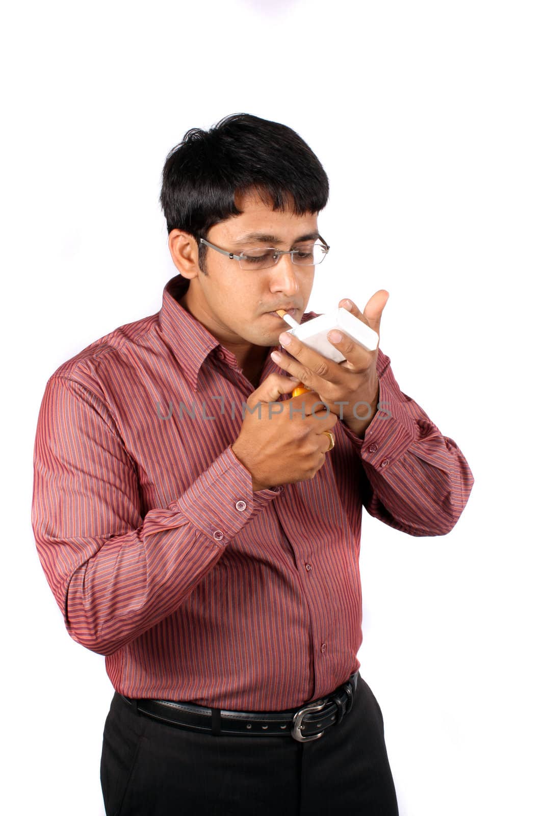 An Indian businessman lighting a cigarette, isolated on white studio background.