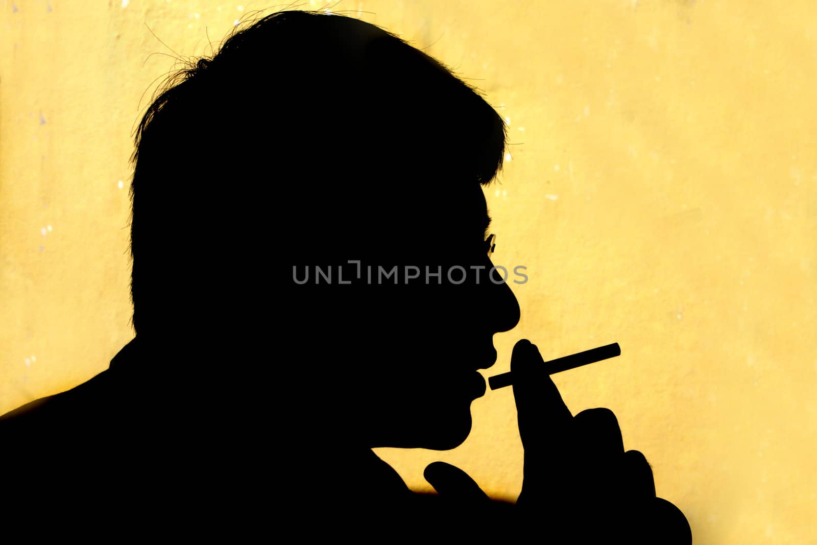 A metaphorical image of a silhouette of a guy smoking. The silhouette represents the hazard of smoking.