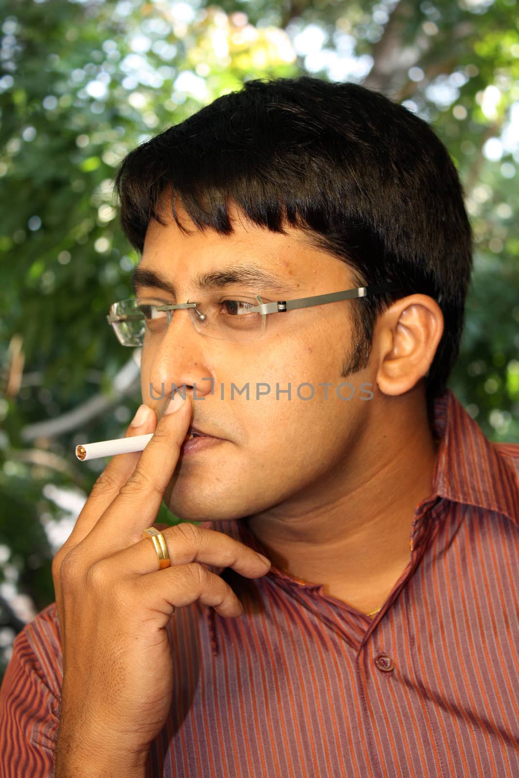 A portrait of a smoking Indian man.