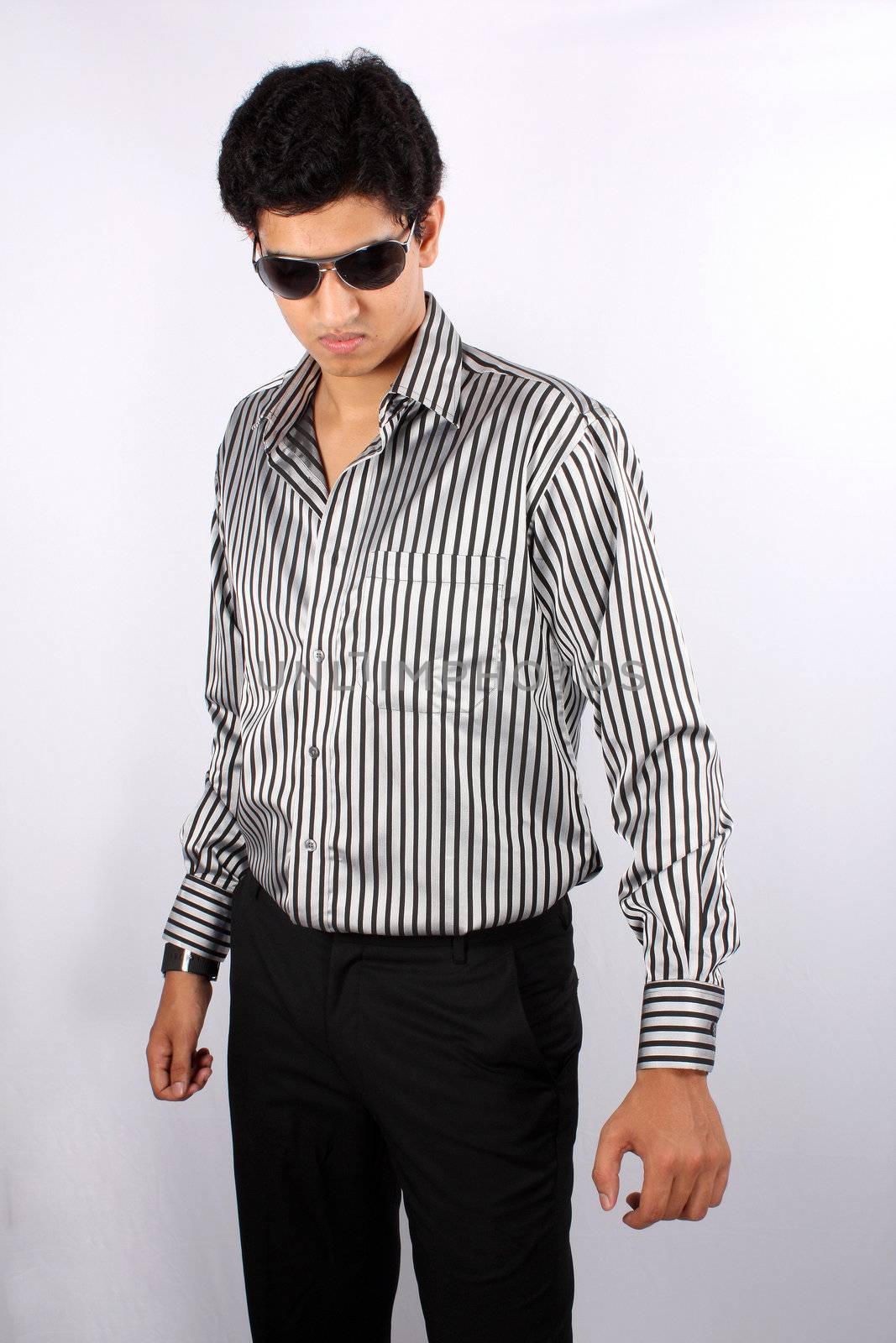 A stylish Indian teenager wearing sunglasses, on white studio background.