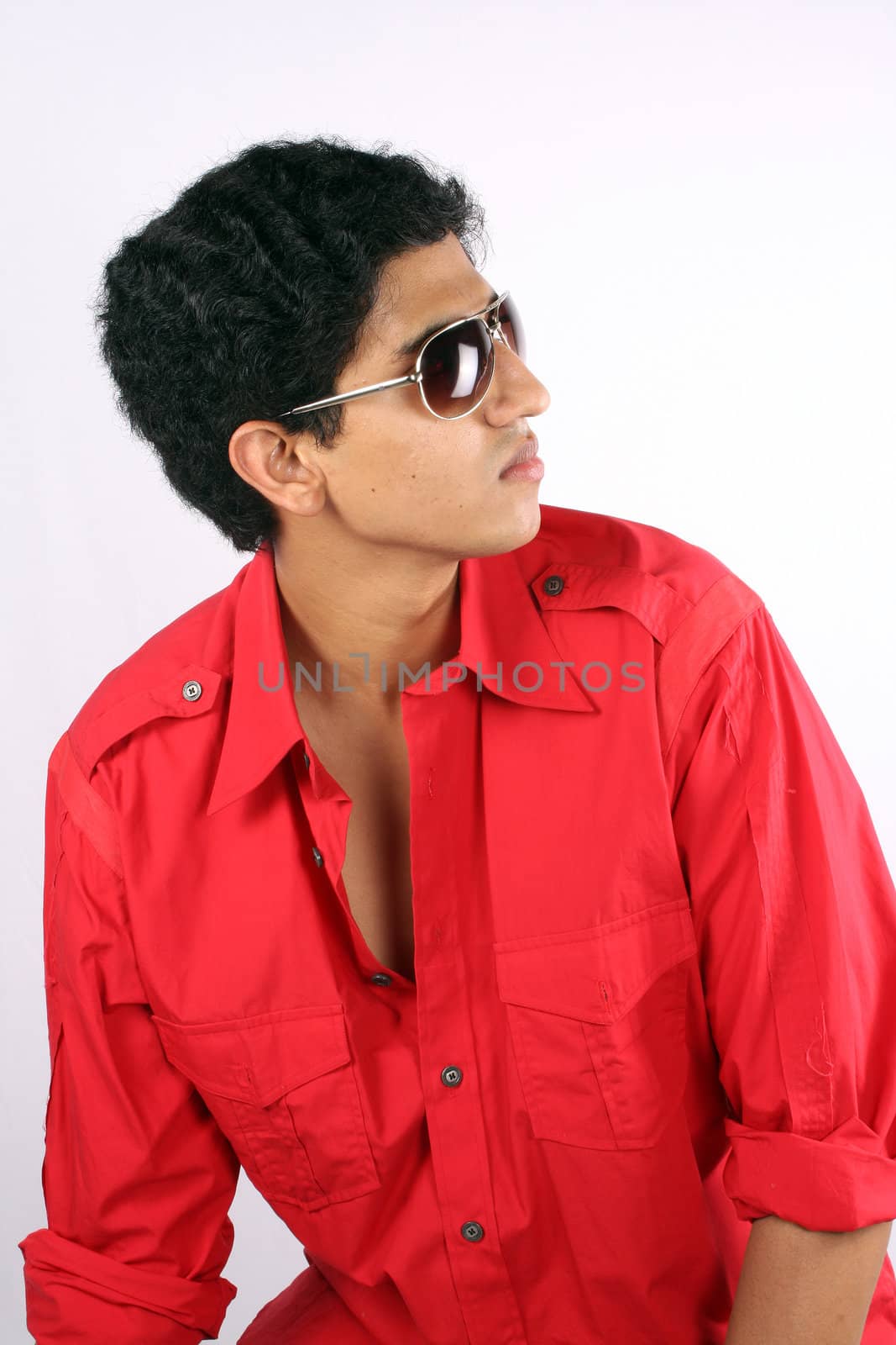 A portrait of a handsome Indian teenager, on white studio background.