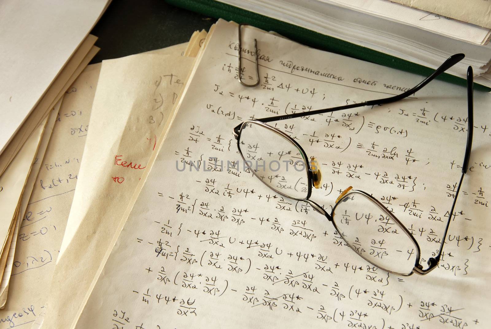 glasses over physics formulas and calculations written on paper