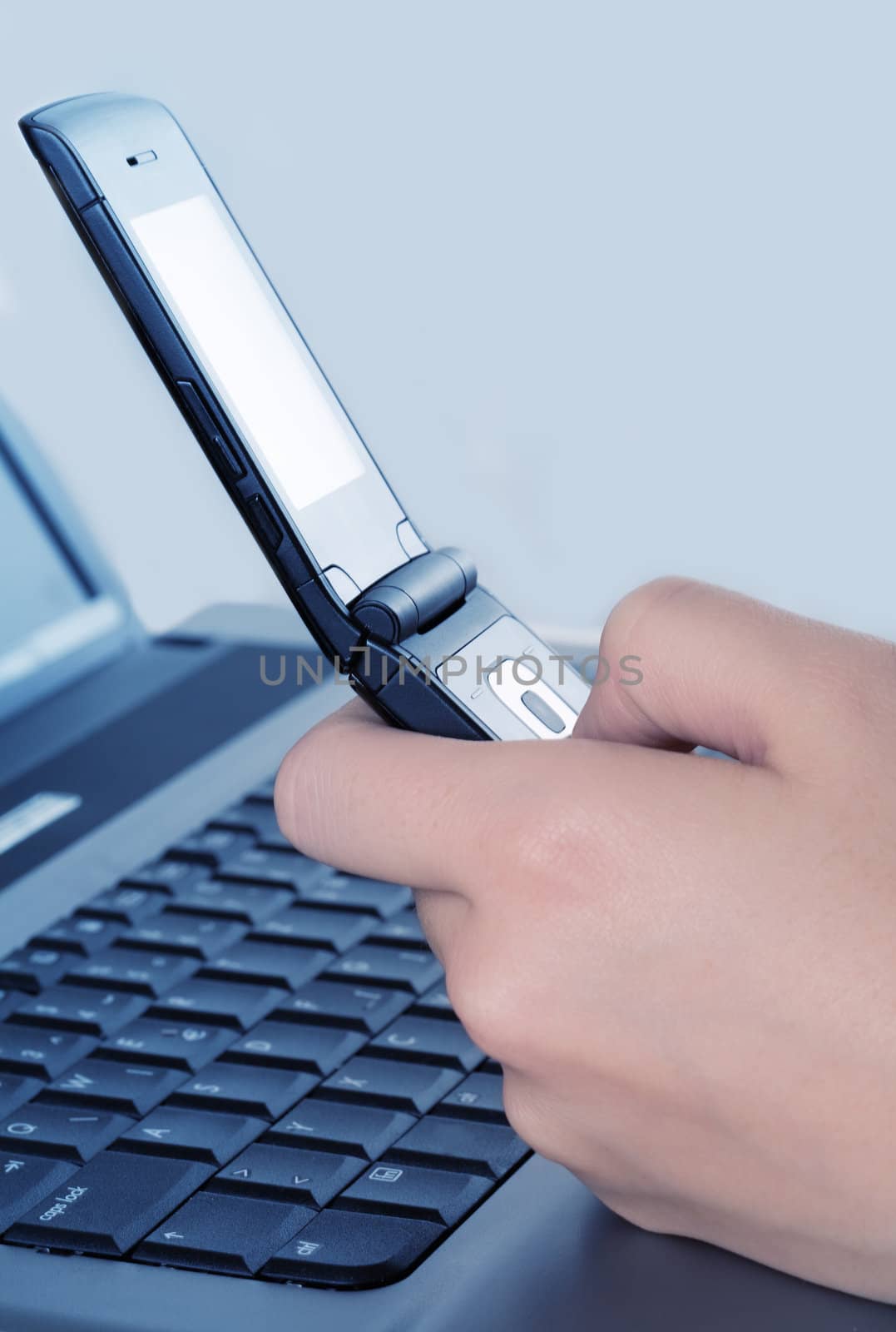 Cell phone dialing and laptop in background - studio photo