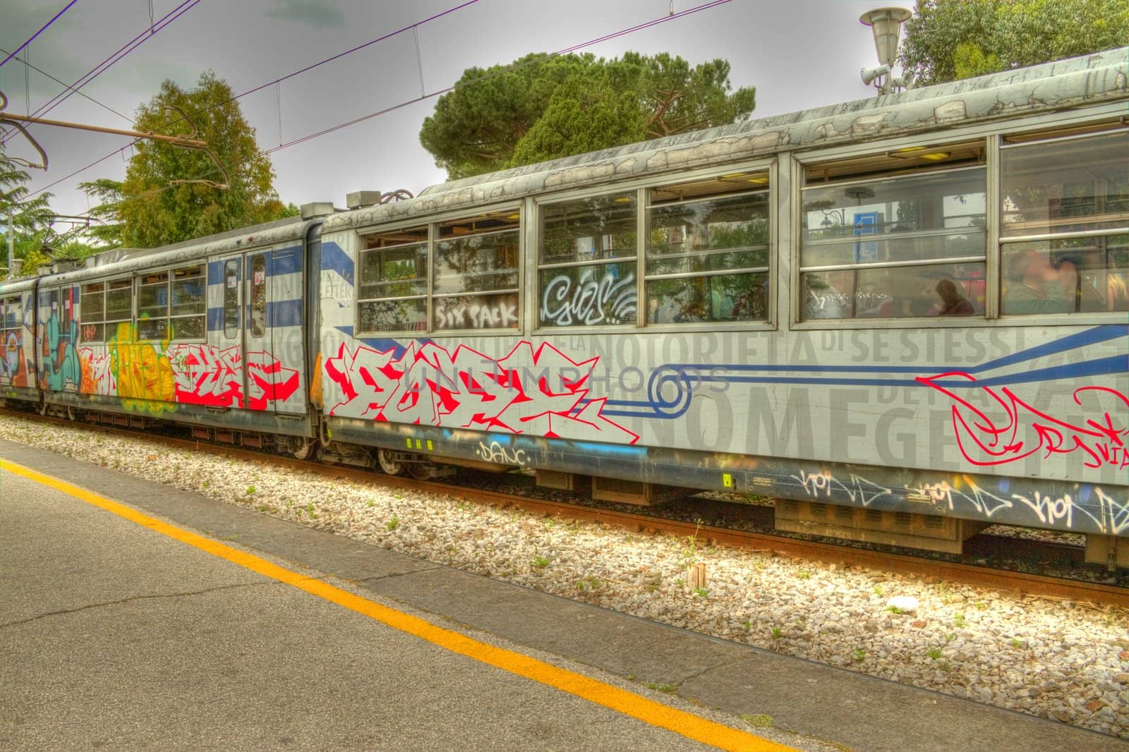 Italian passenger rail cars with graffiti in HDR.