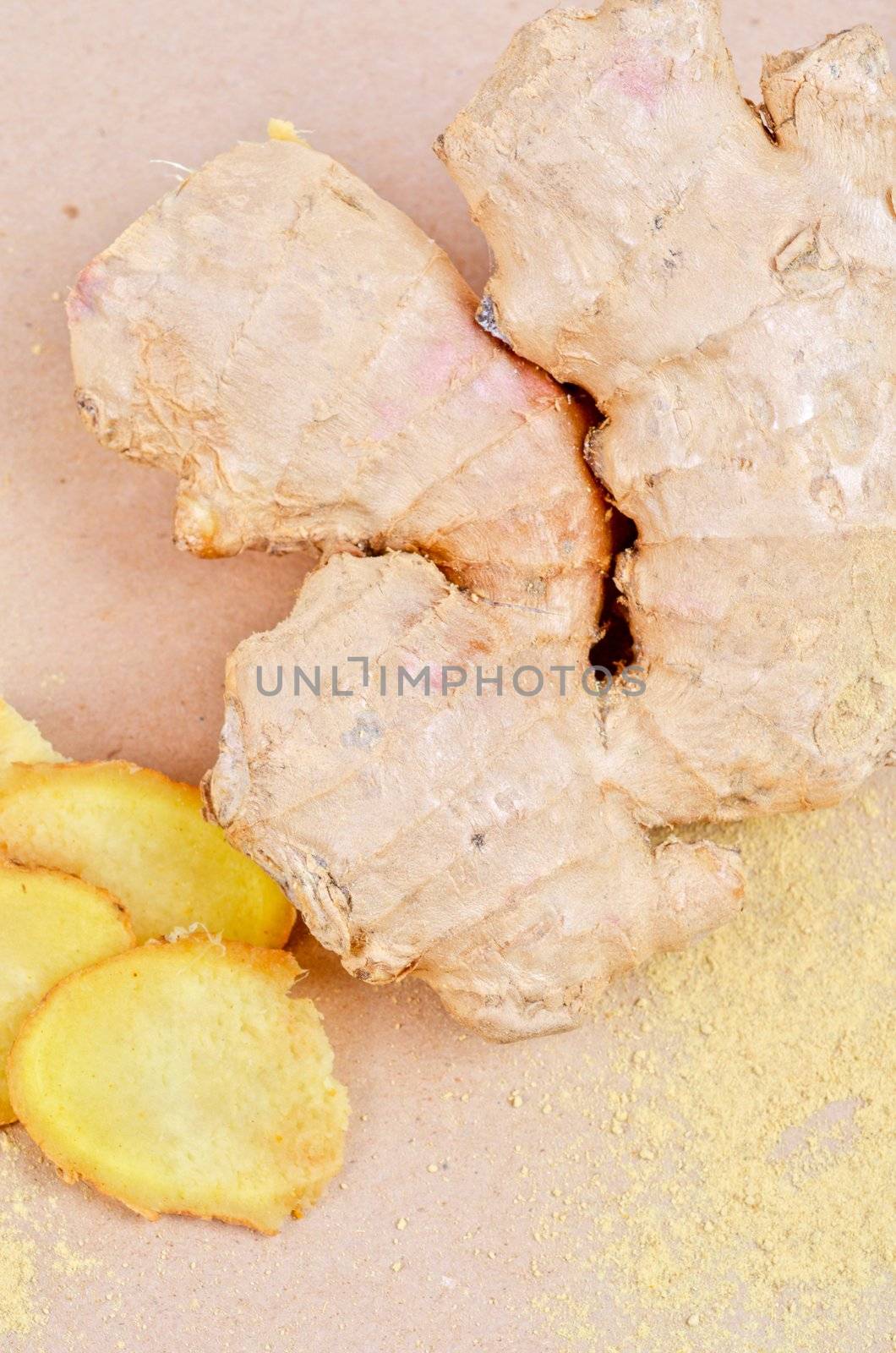 Fresh, dried and powdered ginger at brown background