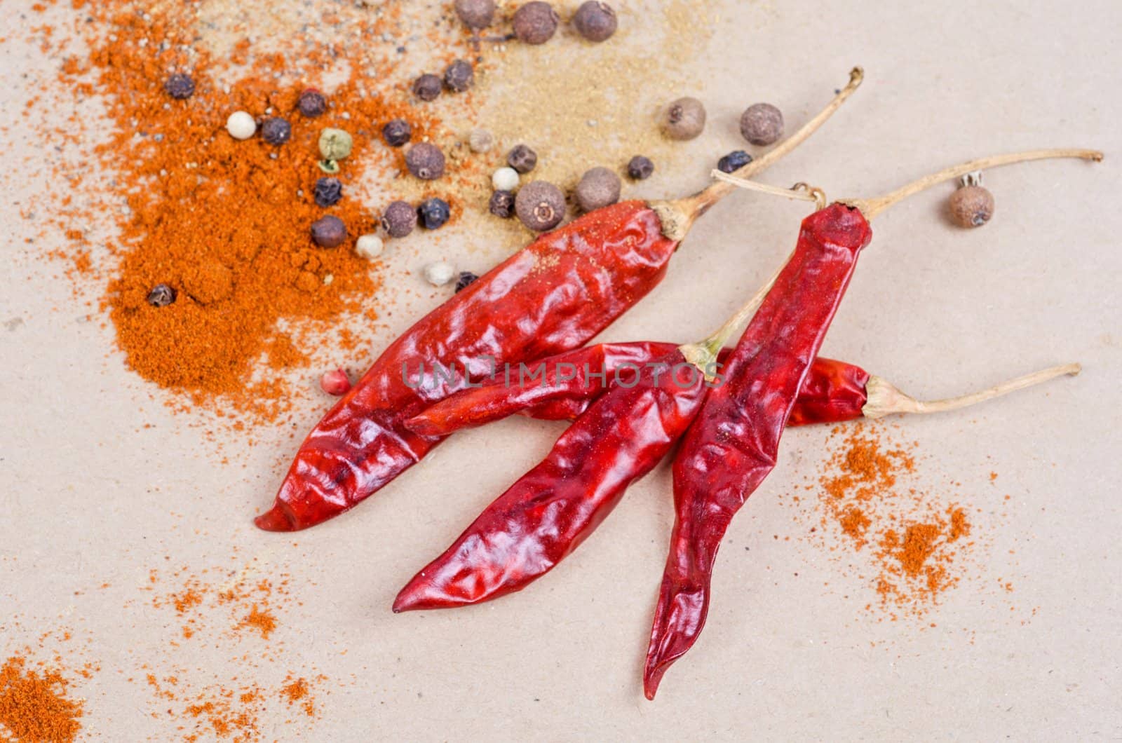 dried peppers and other kind of peppers spices on a brown background