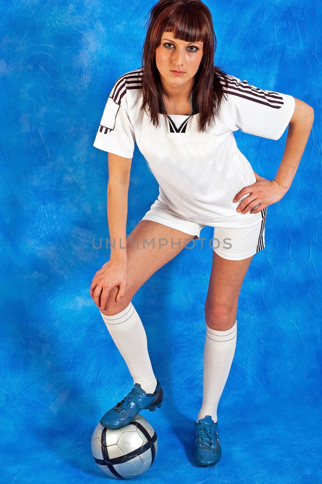 Young girl with the football on the blue mosaic background