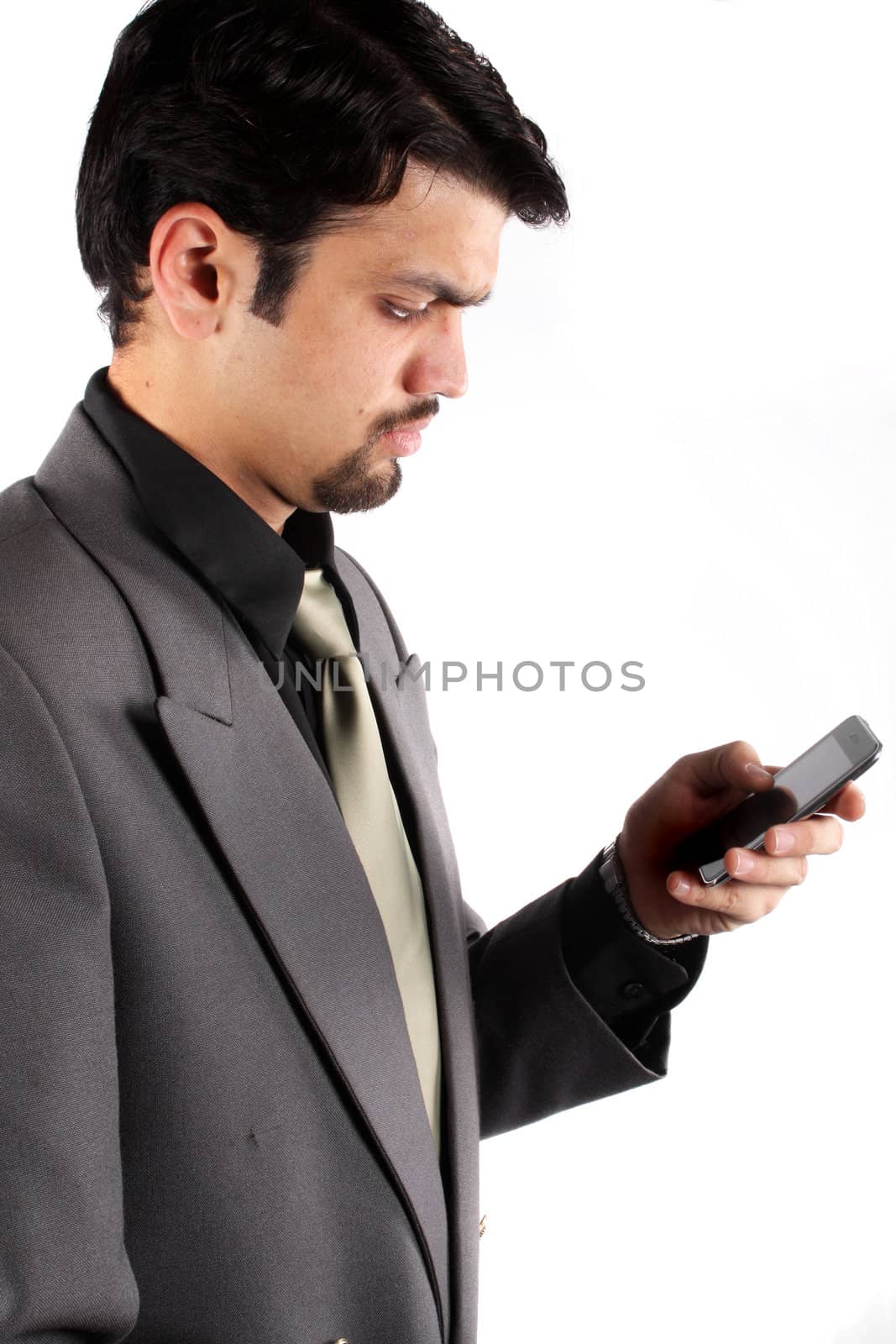 An Indian businessman checking his cellphone, on white studio background.