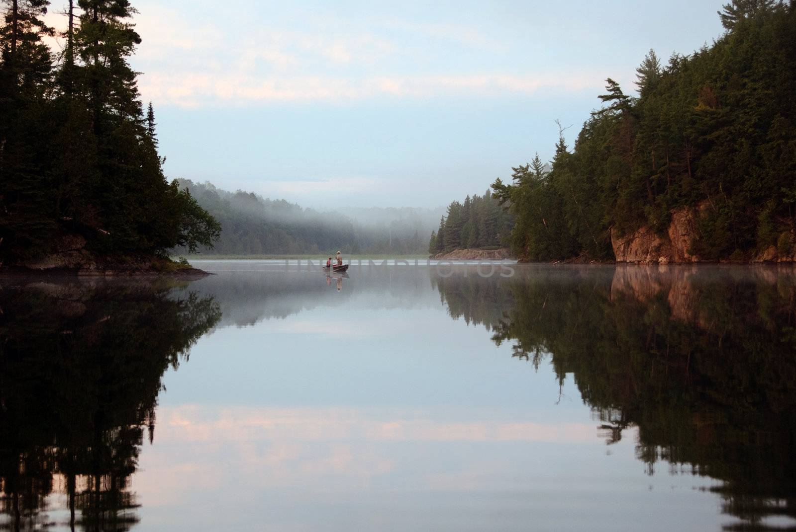 Fisherman on a lake at sunset