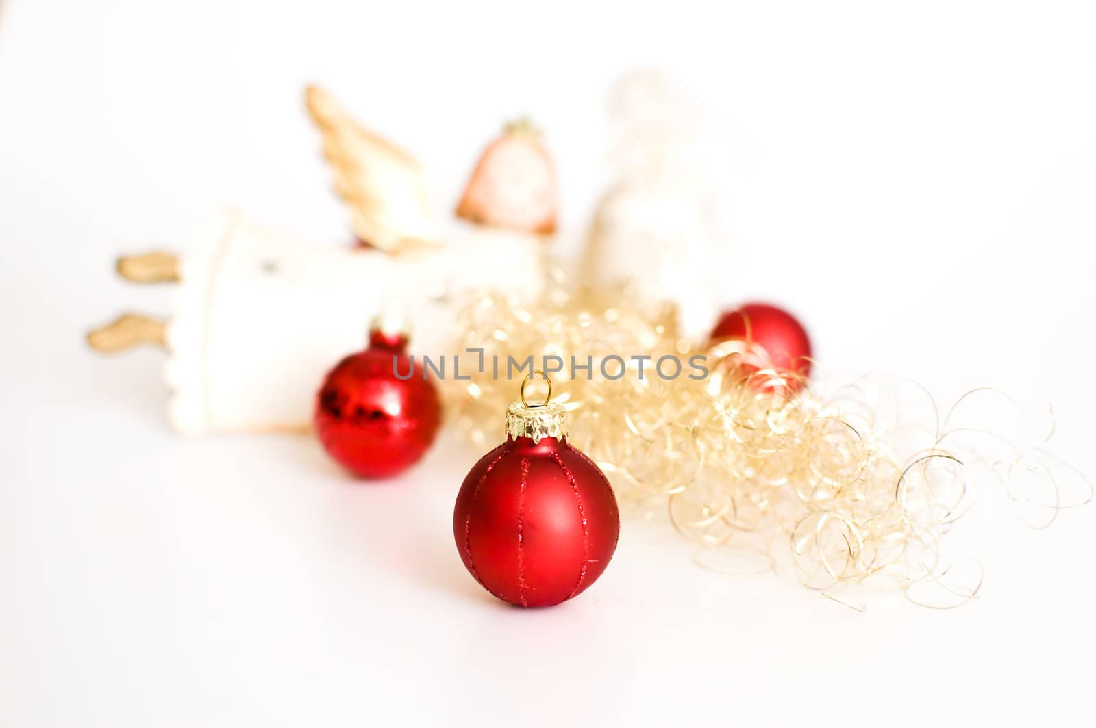 three red christmas balls and an angel with golden decoration