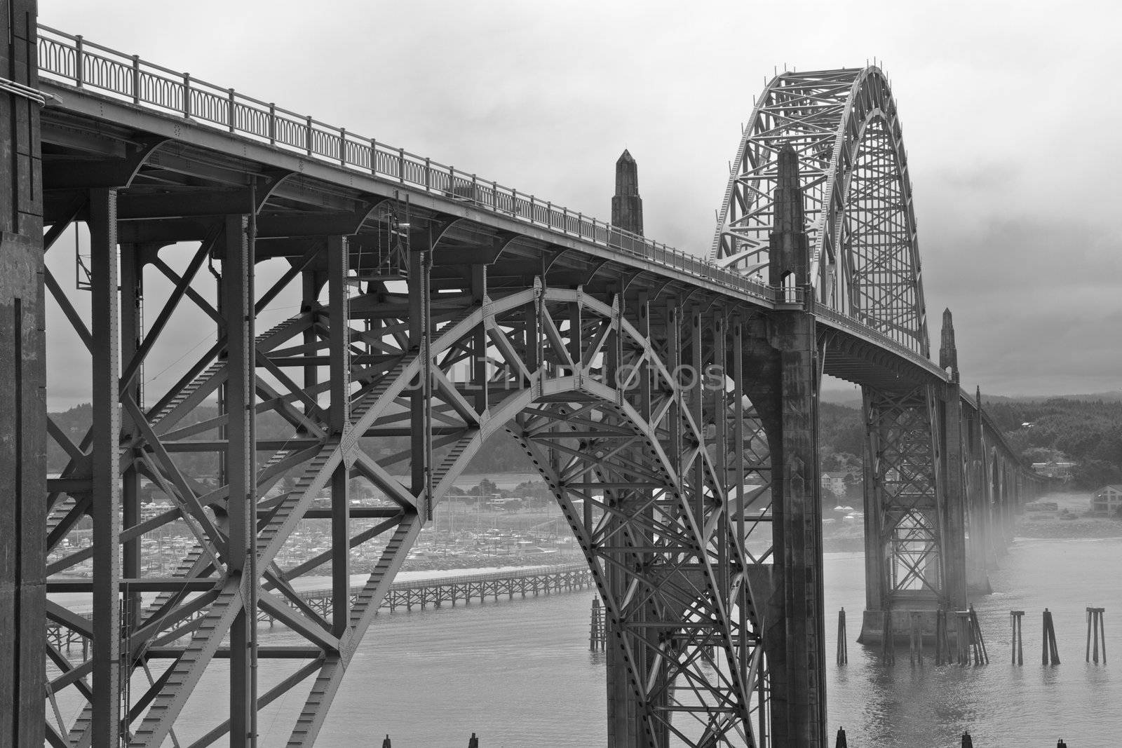 Old green metal bridge disappearing into the mist as a black and white image