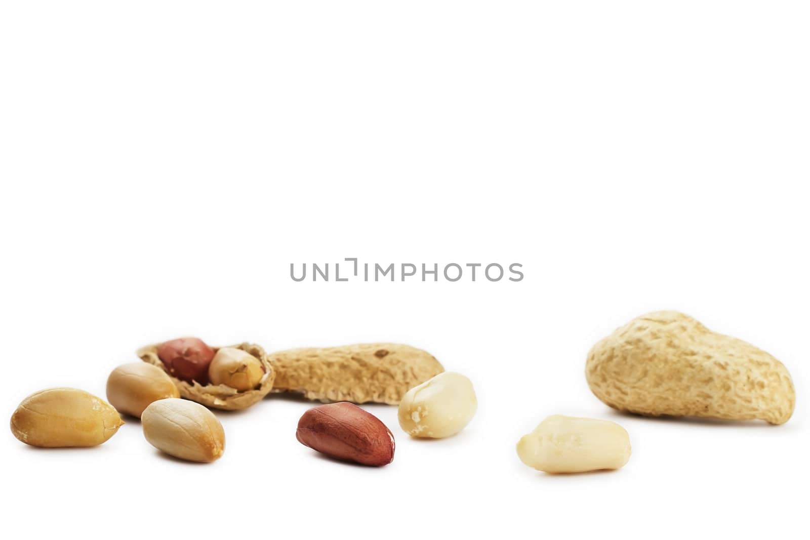 some cracked and closed peanuts on white background