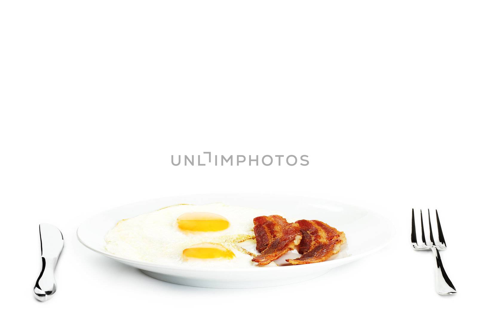 fried eggs and bacon on a plate on white background
