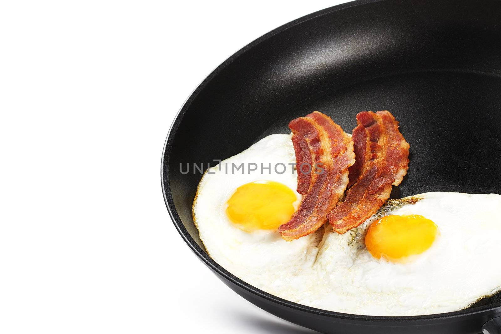 two fried eggs and two pieces of bacon in a pan on white background