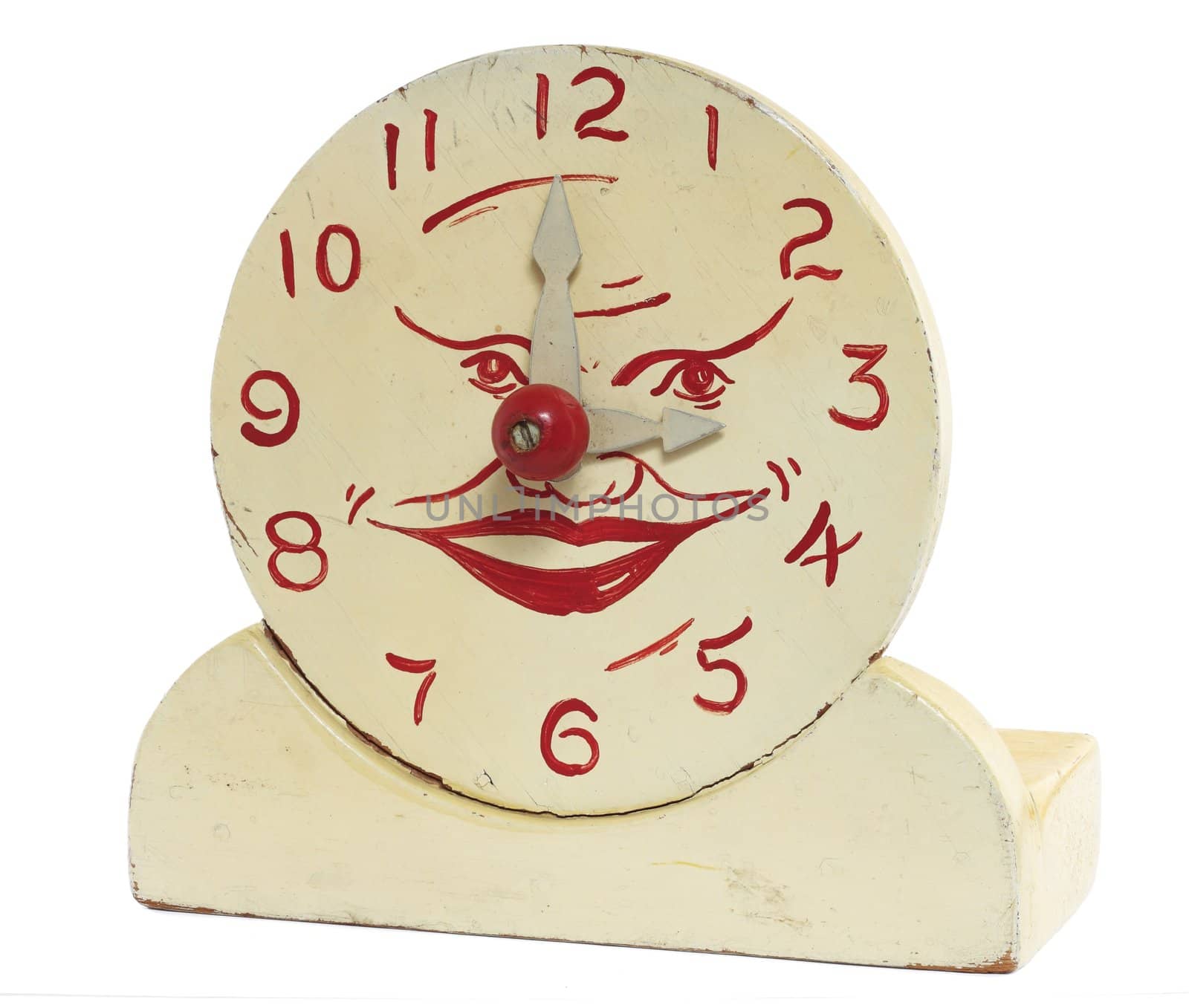 An old handcrafted wood toy clock isolated on white with clipping path. Hand painted white with red numerals and a face at the center.
