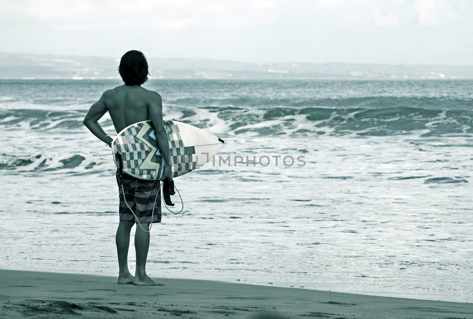 Lonely the man-surfer on a coastline. Bali