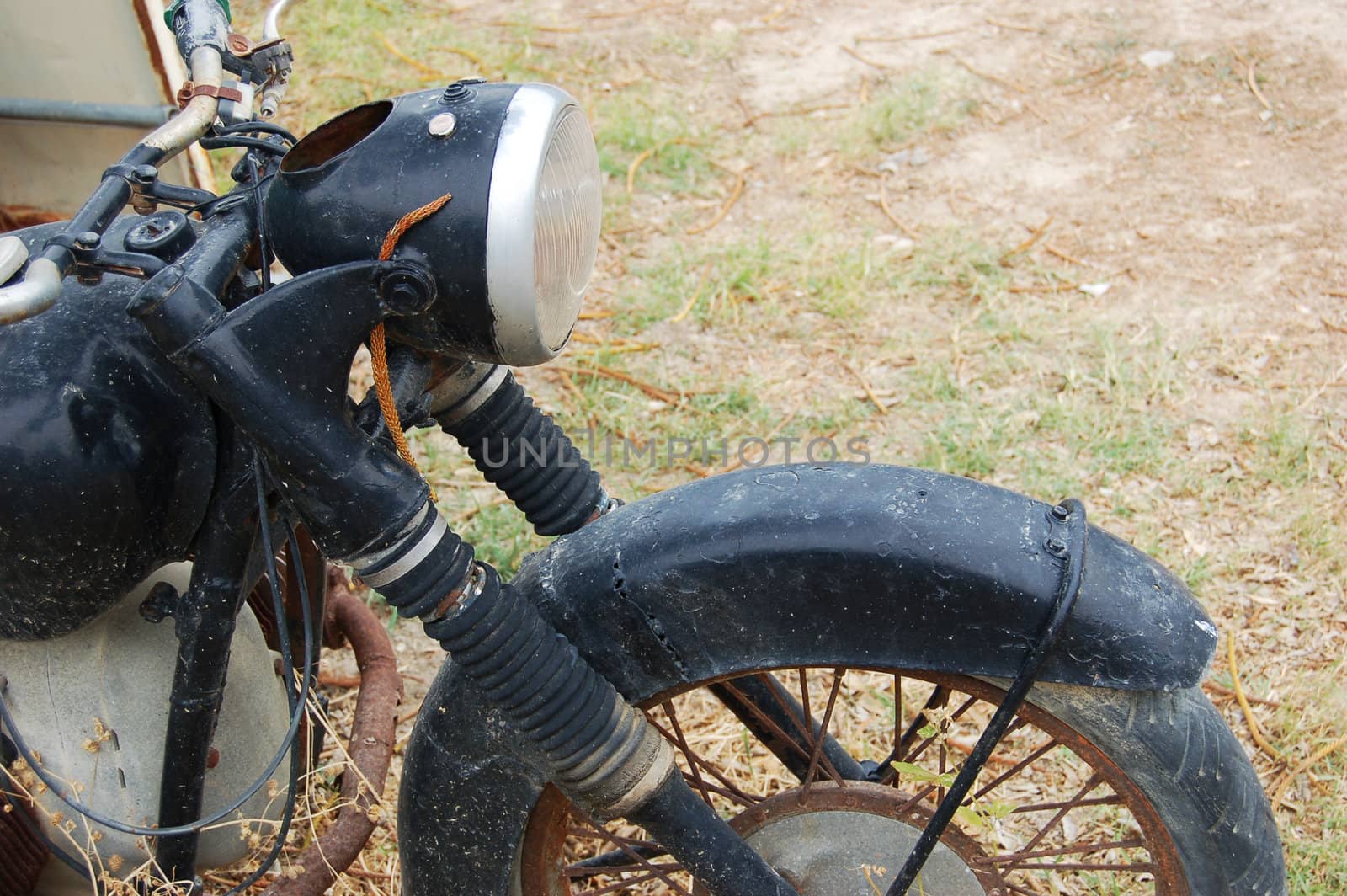 Old rusty damaged motorbike over grass.