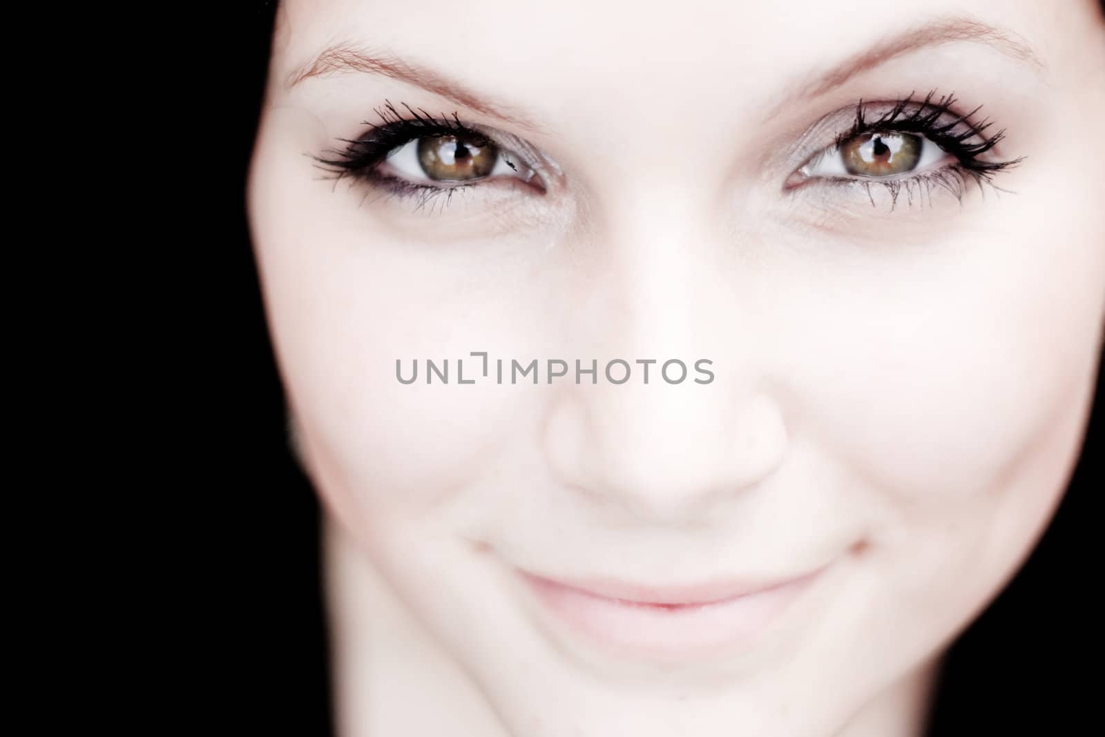 Close up of a beautiful young womans pretty face with copy space in sepia tone.  Shallow depth of field with sharpest focus on the eyes.