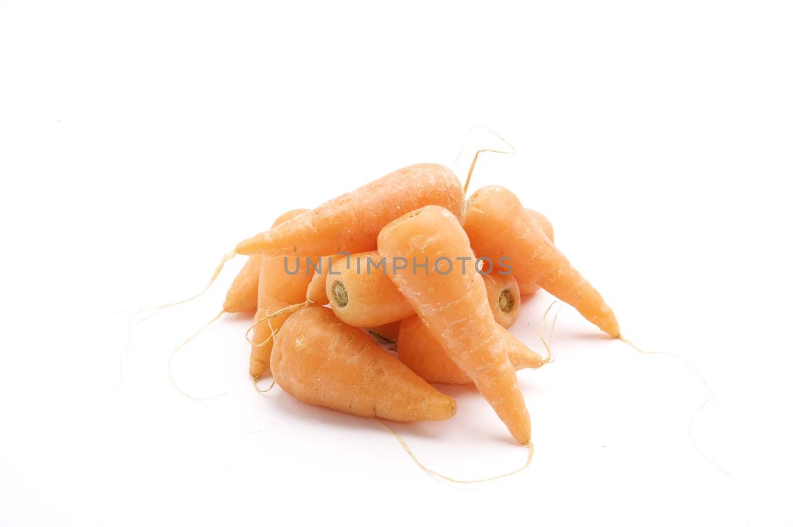 Fresh baby Carrots, isolated on a white background table, lit with a large light source from the above right.