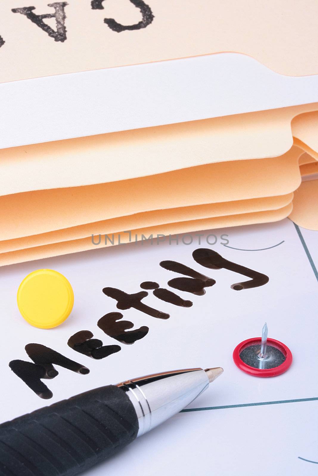 The information on a calendar about meeting with office accessories.