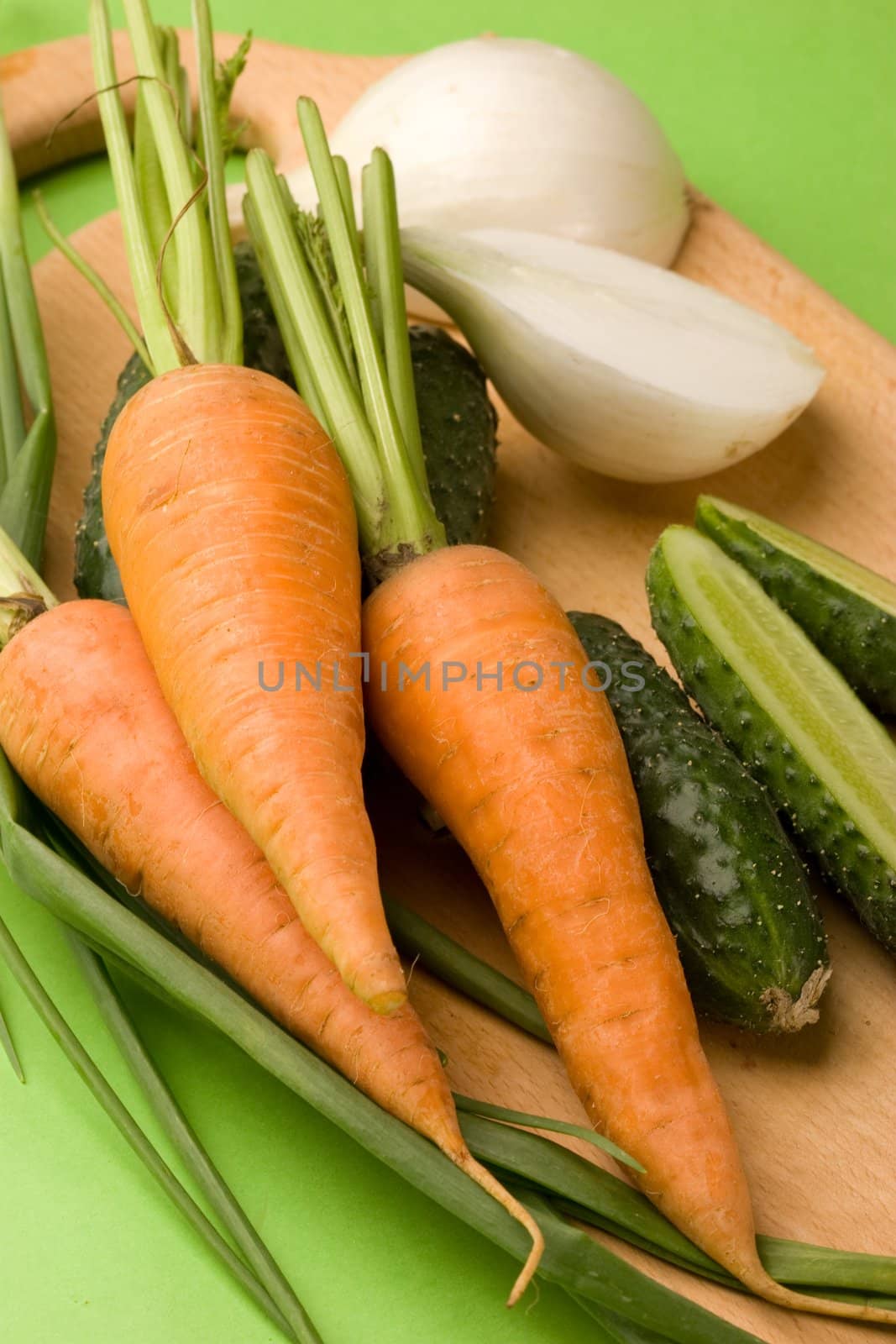 vegeterian food, fresh vegetables: onion, carrot, cucumber on the board