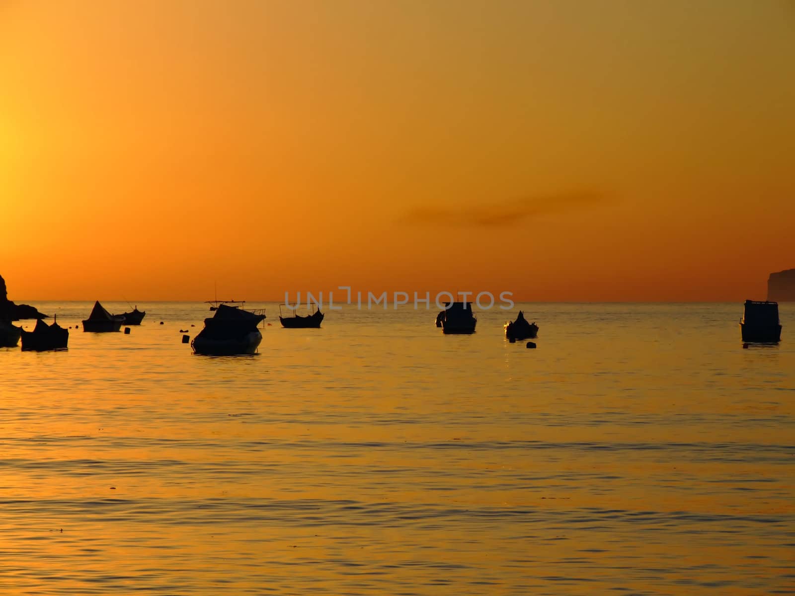 Typical Mediterranean sunset in a tranquil beach in Malta.