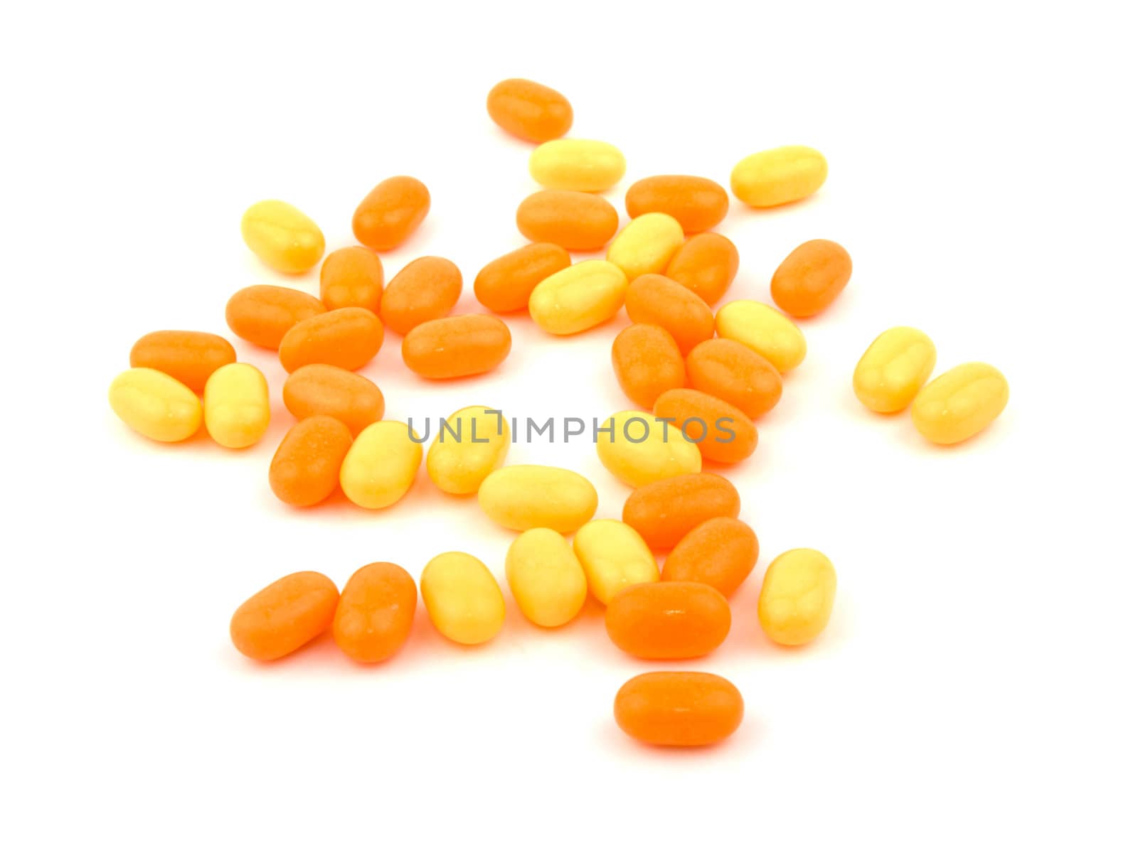Orange and yellow candies on white background