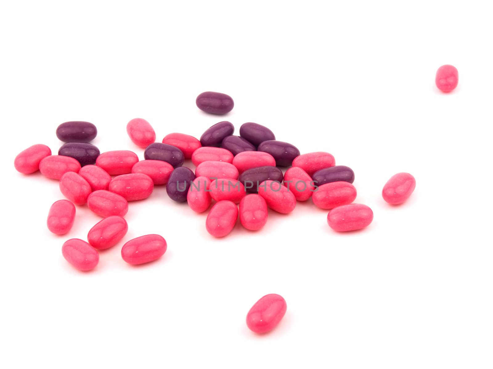 Pink and purple candies on white background