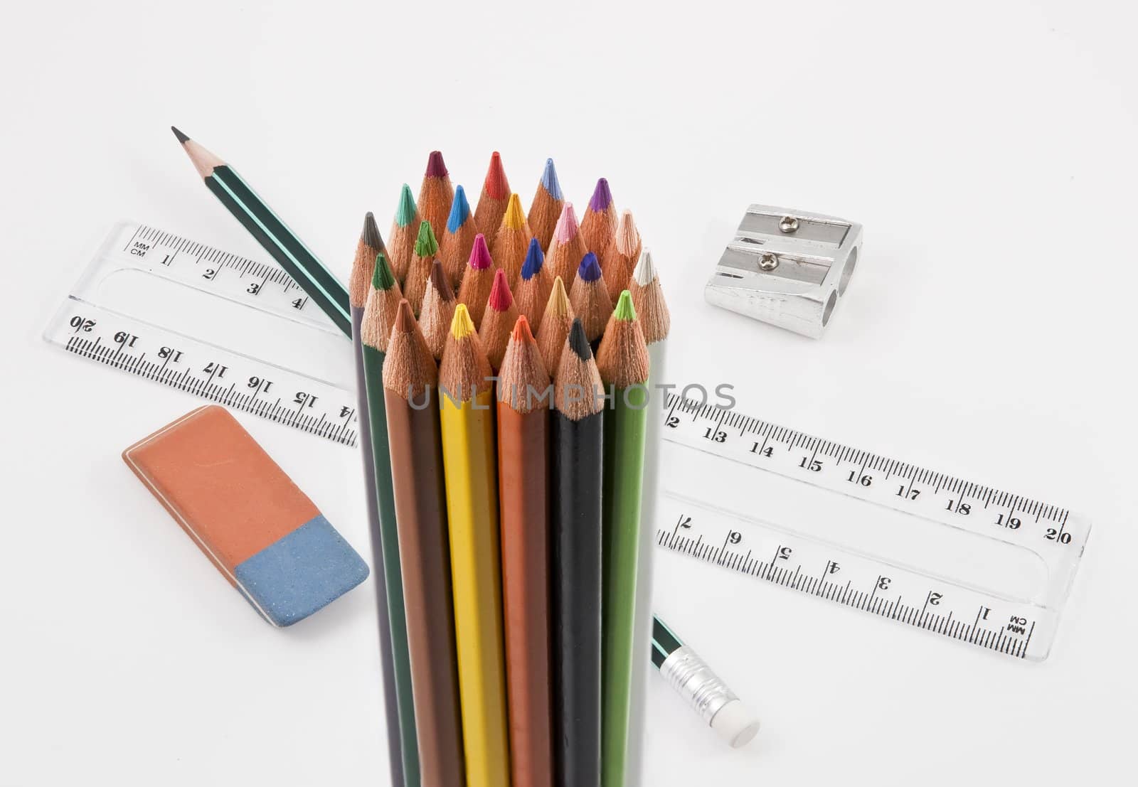 Group of colored pencils with basic school supplies on a white background