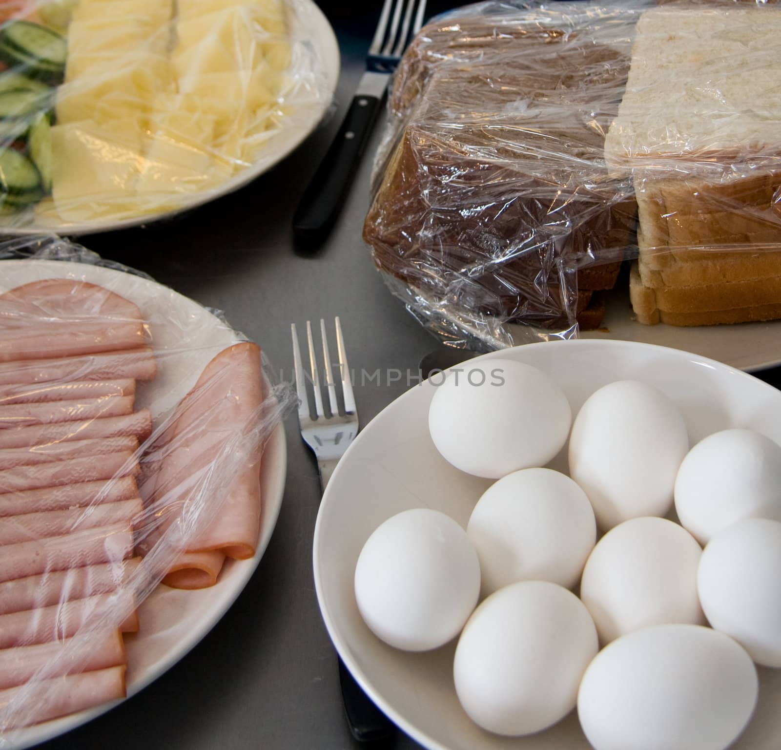 eggs ham cheese bread with plastic film on wating for beeing served.
