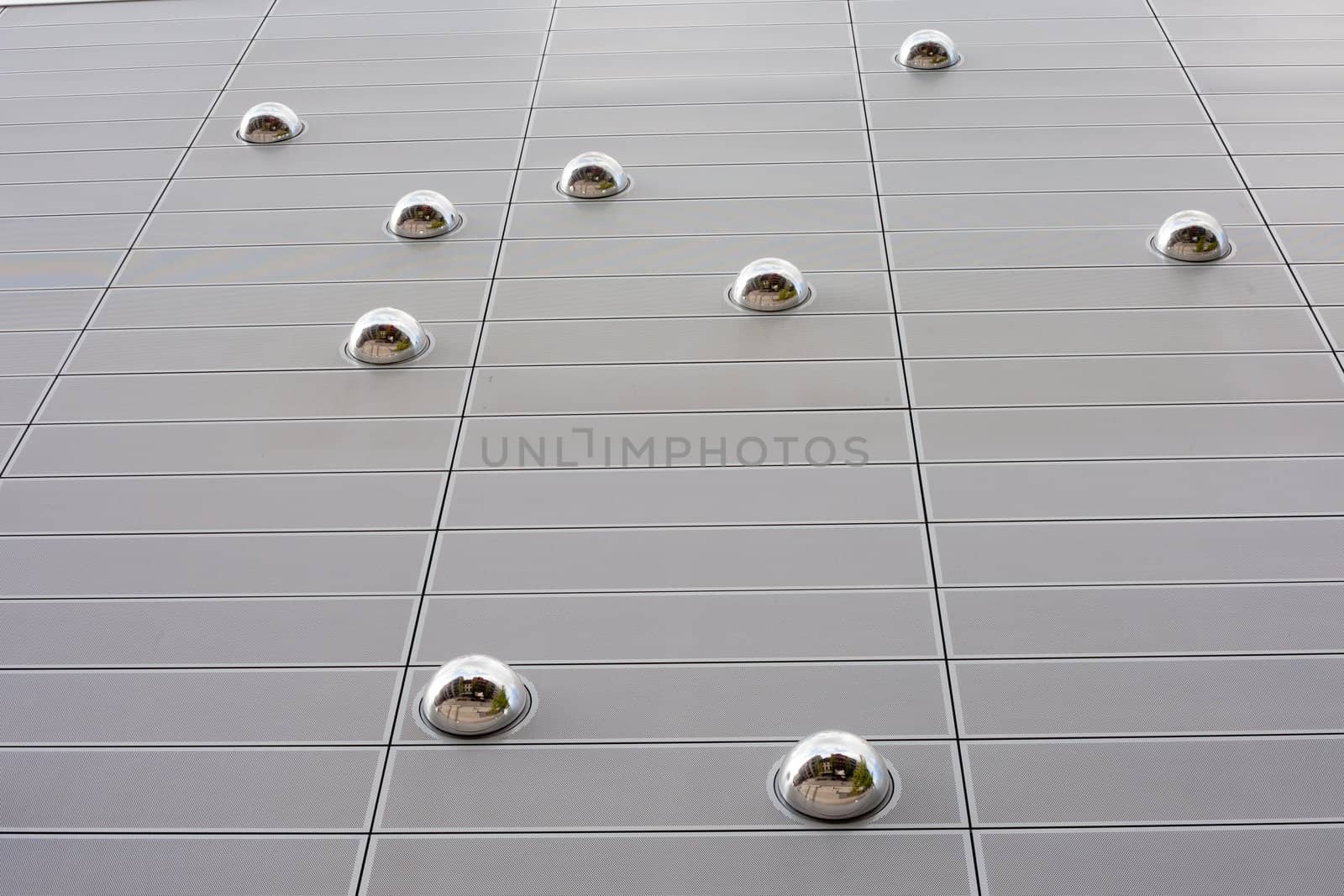 Mirror spheres in modern buiding facade reflect downtown street.