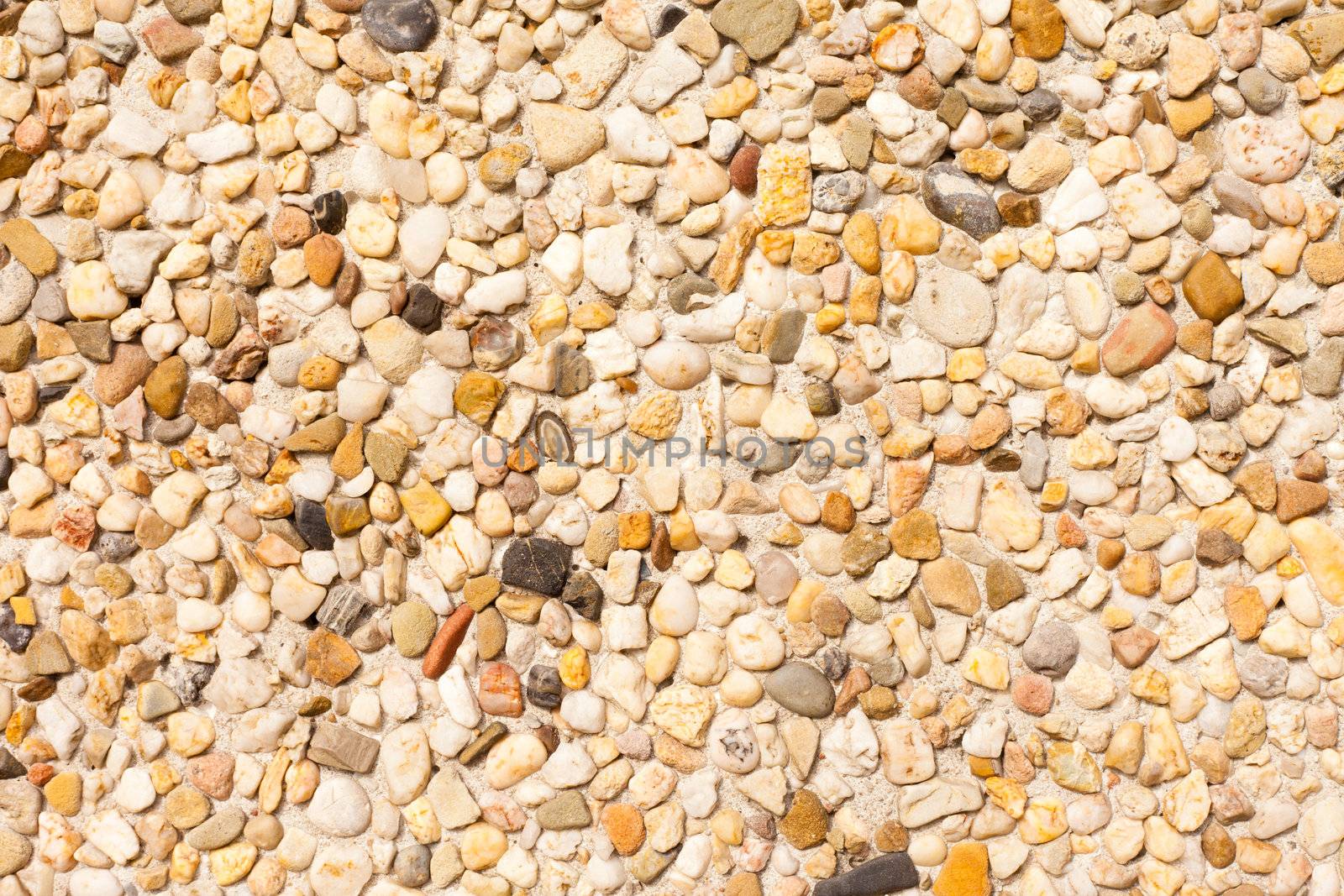 Small colorfull pebbles forming surface of concrete wall slab.