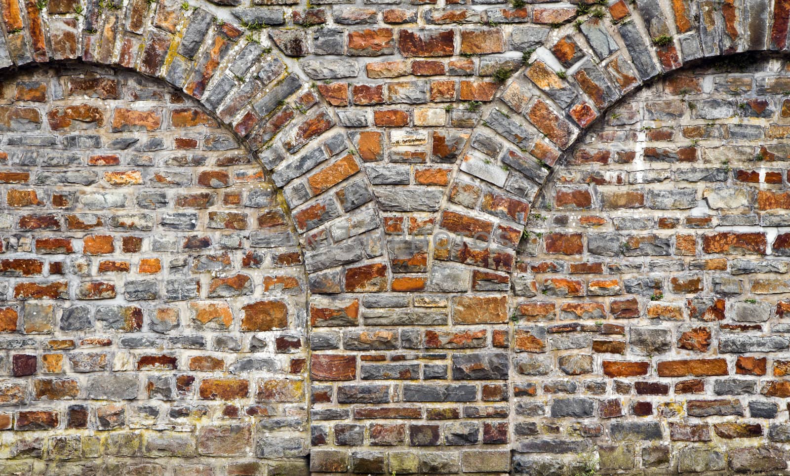 Cut out rocks in wall with arched brickwork by Colette