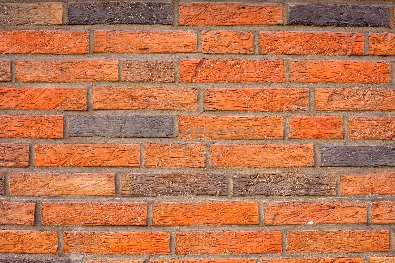 Background texture pattern of exterior wall made of red and black bricks.