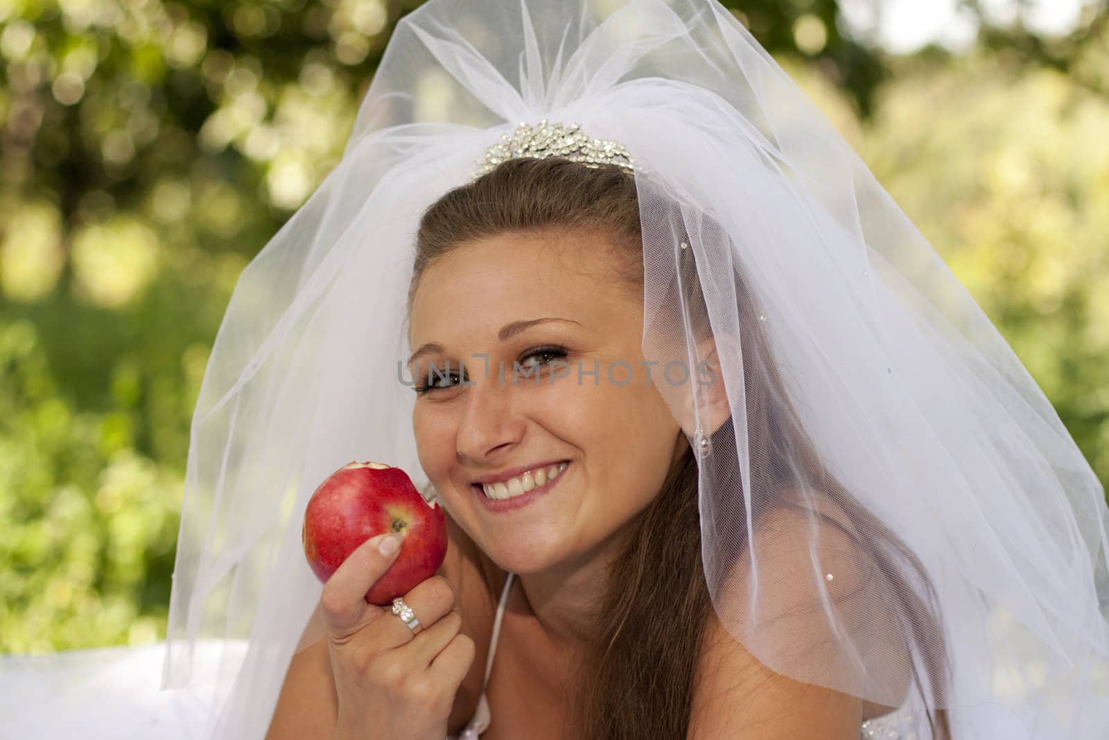 Bride in a good mood eating apple