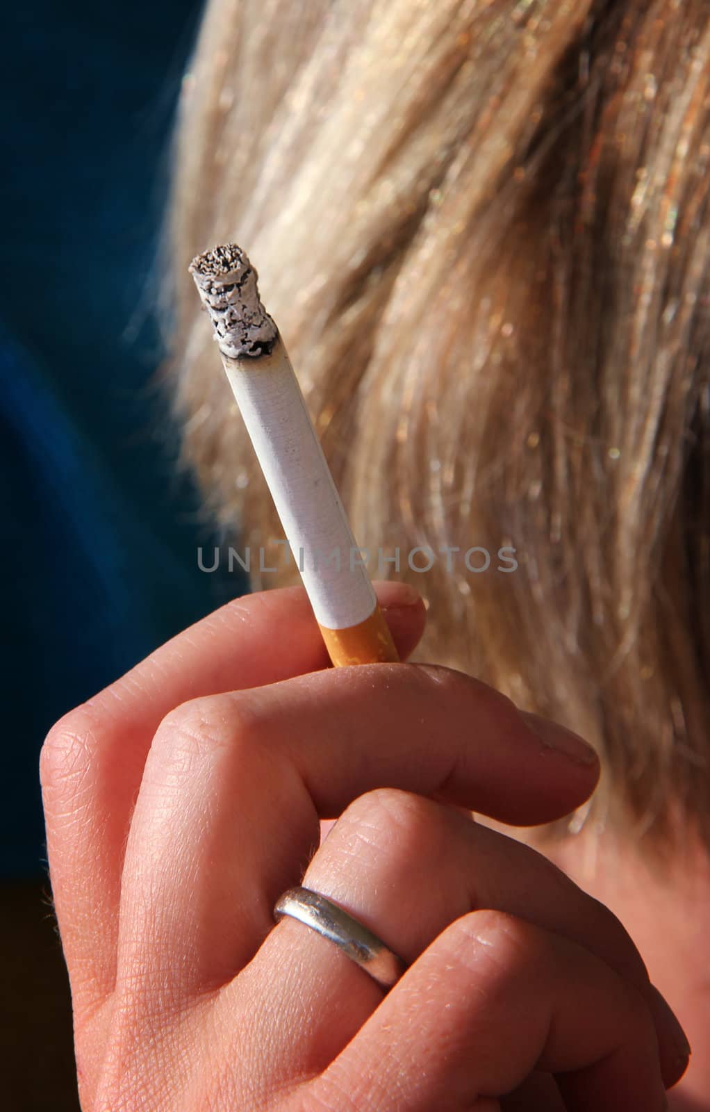 woman is holding a cigarette in her hand