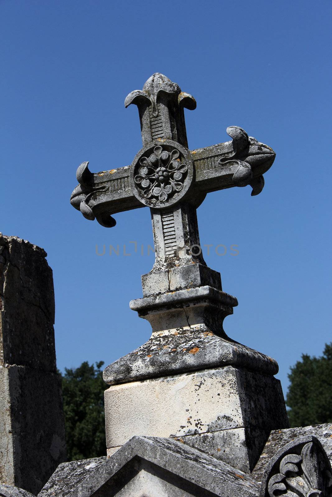old massive cross of a tombstone on a graveyard