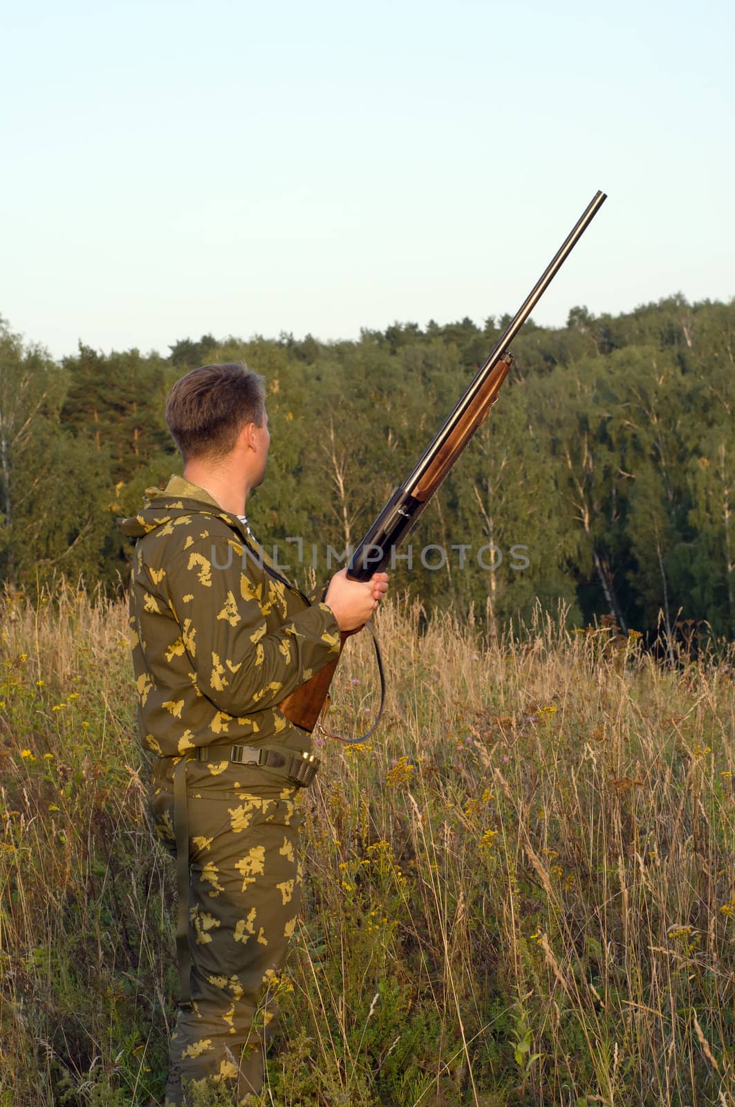 Outdoor shoot of man in camouflage with a shotgun.