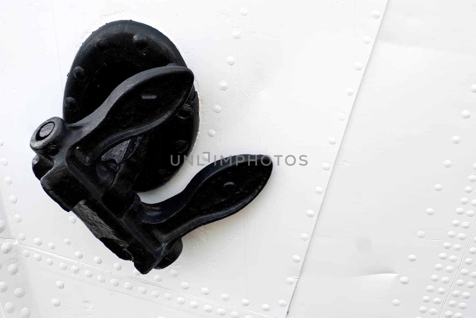 closeup of a black anchor on a white boat
