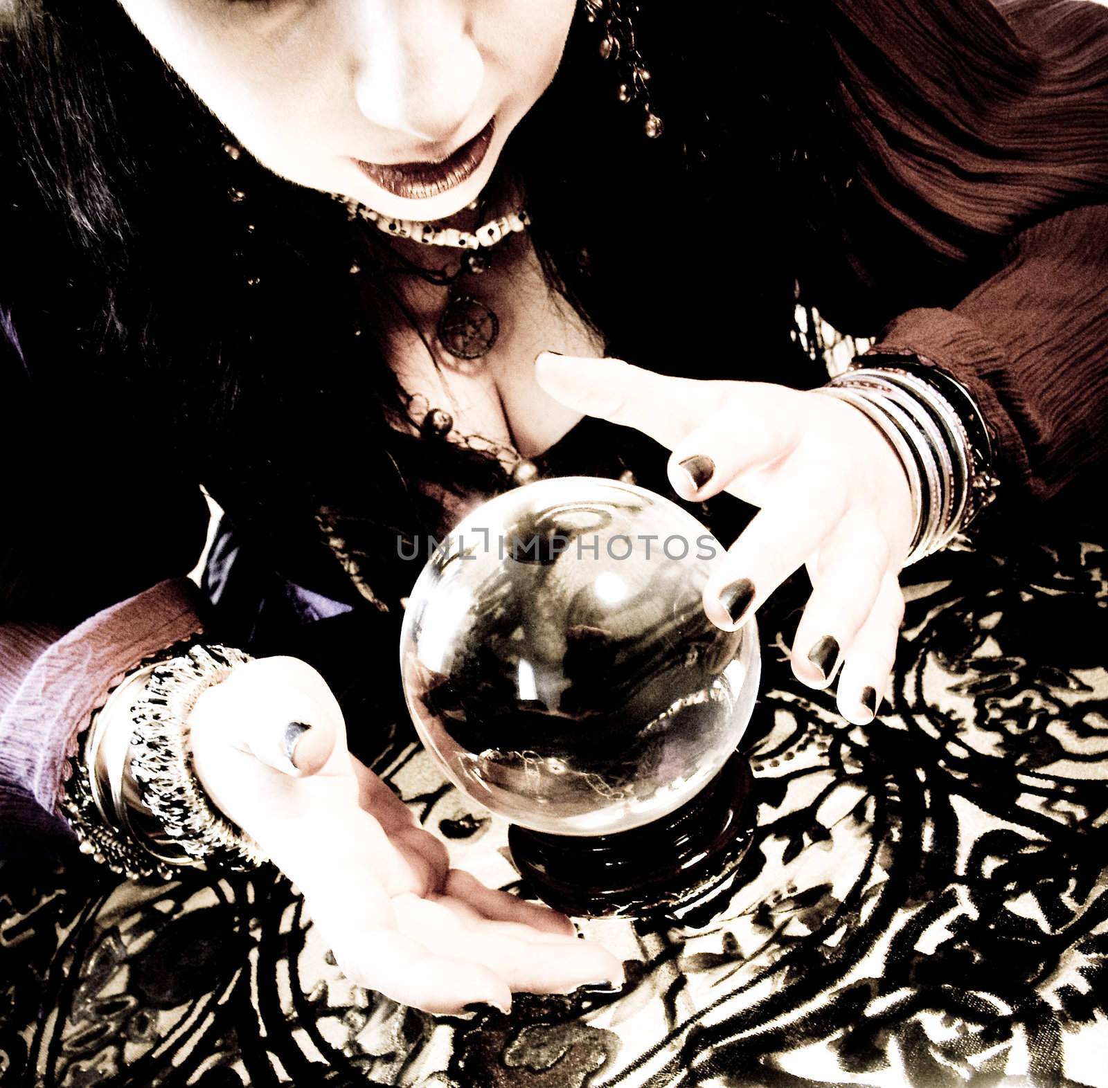 A fortune teller leans over her crystal ball