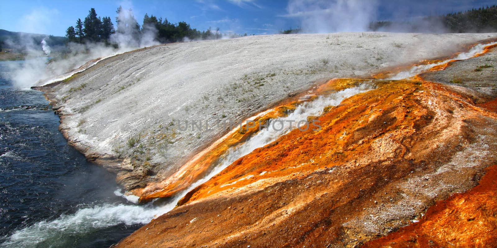 Hot water from the Midway Geyser Basin cascades into the Firehole River in Yellowstone National Park - Wyoming.